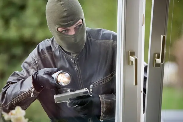 In this file photo, an underemployed model gets paid to inexplicably use a flashlight while reenacting a broad daylight burglary.